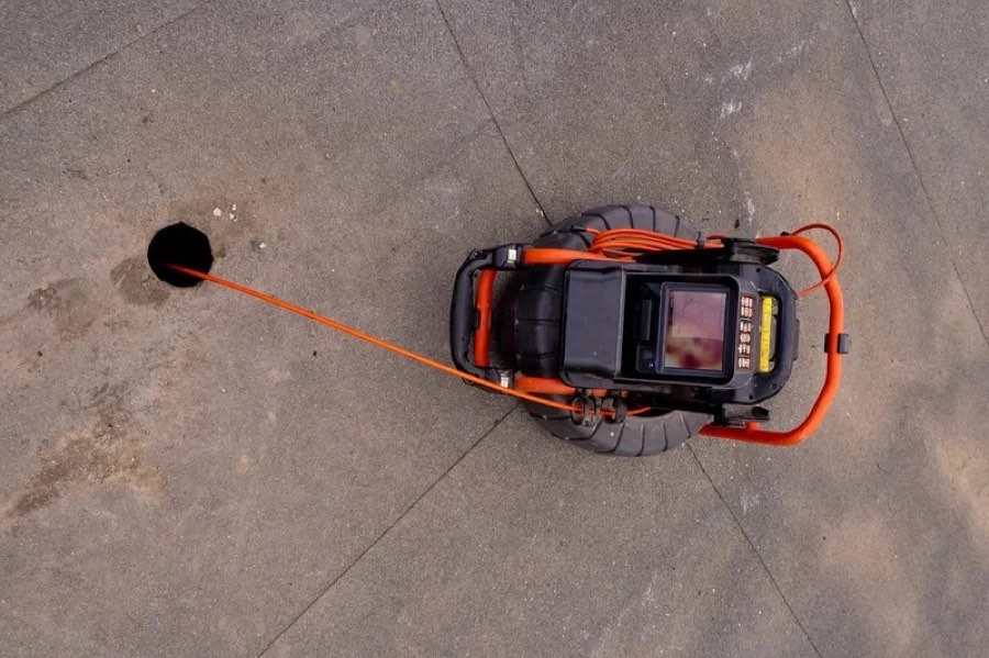 De inspectiecamera bovenaan gezien, met de kabel die de put in gaat